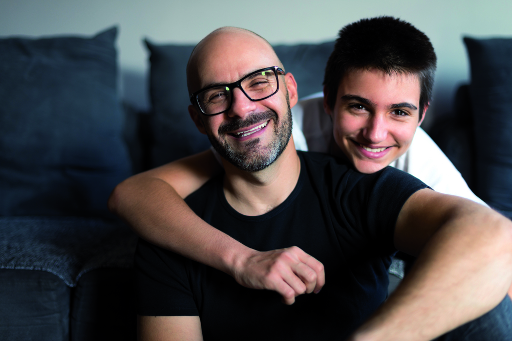Portrait of father and son bonding in a living room.